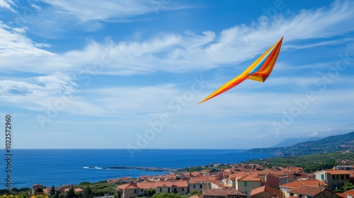 A colorful kite flying over a coastal town.