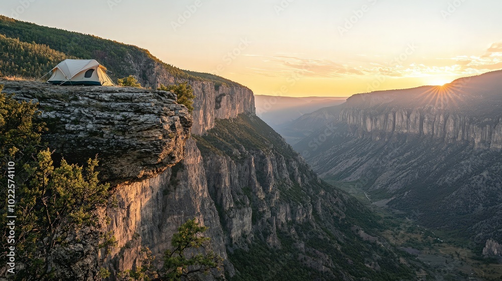 A lone tent sits atop a cliff overlooking a valley as the sun sets in the distance. A lone tent sits atop a cliff overlooking a valley as the sun sets in the distance.