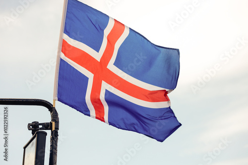 The flag of Iceland is attached to the mirror of a tourist bus, fluttering  photo