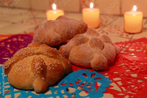 Traditional Pan de Muerto, candles and paper ornamets on talavera stoves photo