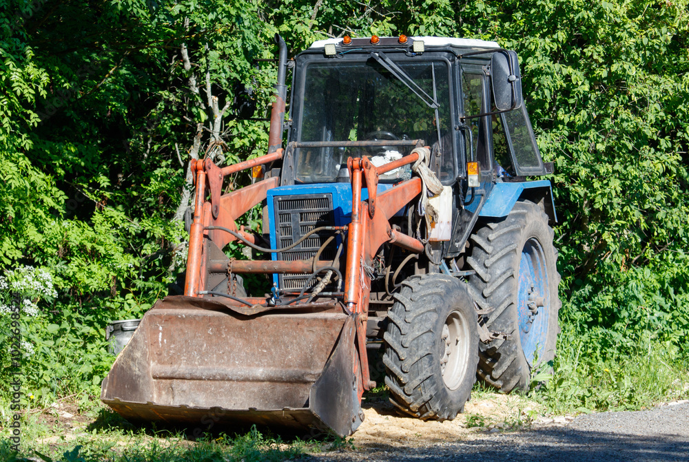 A tractor with a large orange bucket on the front A tractor with a large orange bucket on the front