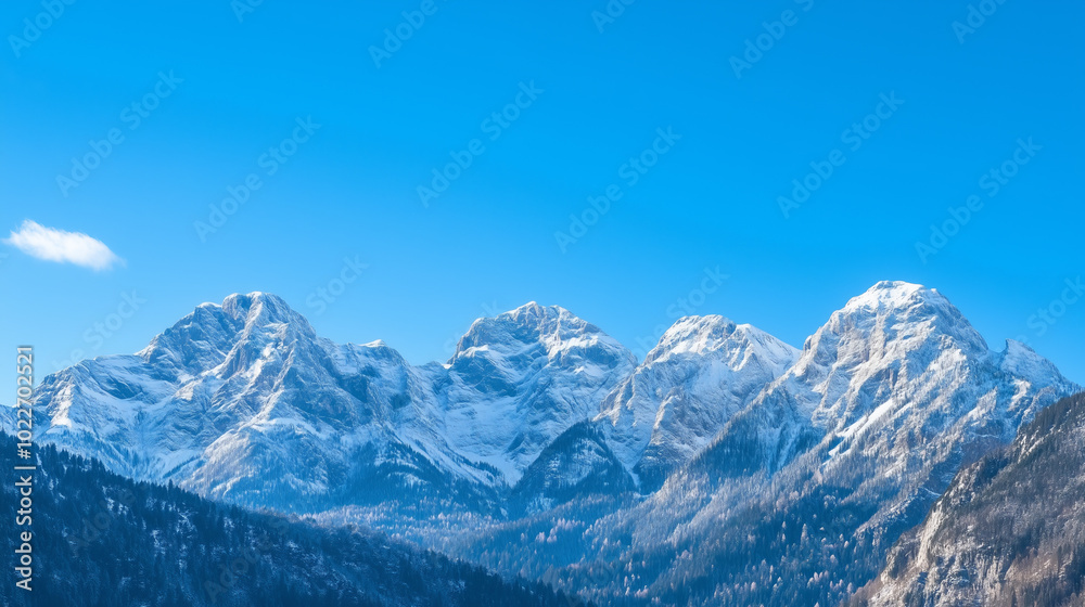 Snow-capped mountain peaks rise against a clear blue sky. Snow-capped mountain peaks rise against a clear blue sky.