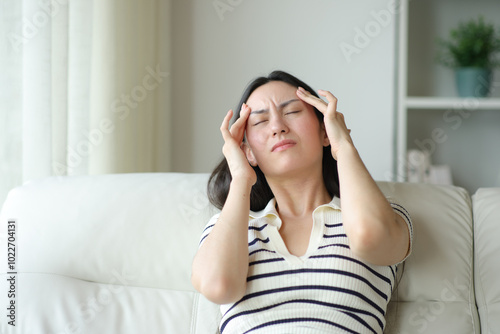 Asian woman suffering migraine at home