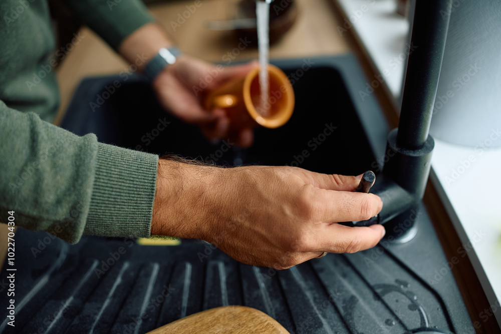 Close up of man doing dishes in kitchen. Close up of man doing dishes in kitchen.