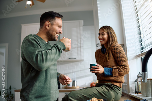 Happy couple enjoying in conversation and cup of coffee in  kitchen. photo