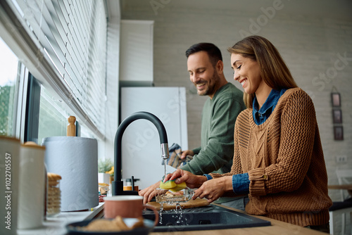 Photos Happy couple doing the dishes together at home.
