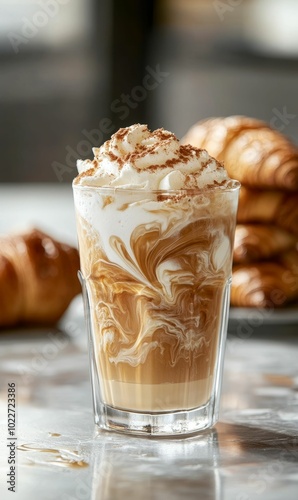 Cinnamon coffee with whipped cream and croissants.