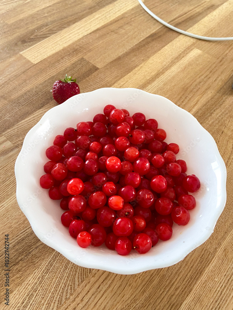 Collection of vibrant red berries sits elegantly in a white bowl, creating a striking contrast against a wooden background. Simple composition showcases the freshness and natural appeal of the fruit Collection of vibrant red berries sits elegantly in a white bowl, creating a striking contrast against a wooden background. Simple composition showcases the freshness and natural appeal of the fruit