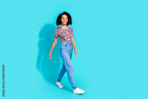 Full body photo of pretty young girl walking wear trendy colorful clothes isolated on aquamarine color background