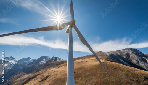 Bright sun shining behind a wind turbine on a mountain ridge during a clear day in the Peruvian Andes