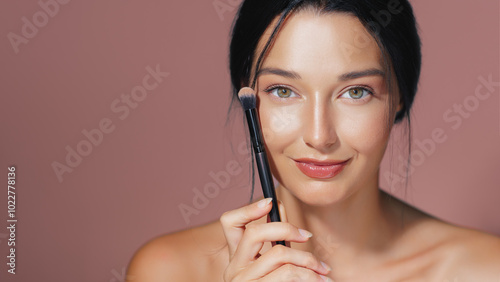 Smiling Woman Holding Makeup Brush, Emphasizing Natural Beauty