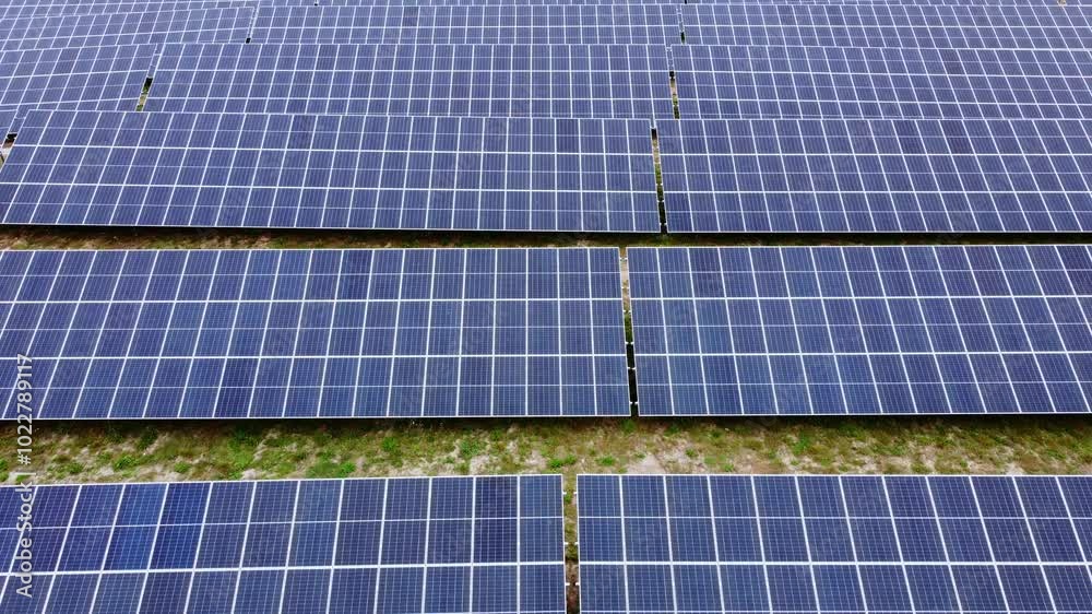 Massive solar panel farm, low angle aerial view Massive solar panel farm, low angle aerial view