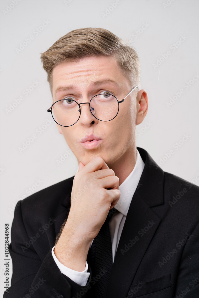 Man wearing glasses and a suit is looking at the camera. He is wearing a tie and has a white shirt Man wearing glasses and a suit is looking at the camera. He is wearing a tie and has a white shirt