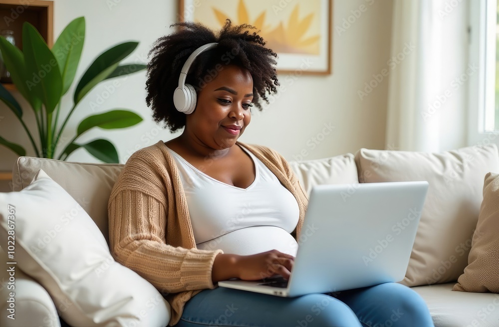 A large African American woman is sitting on the couch and working online on a laptop A large African American woman is sitting on the couch and working online on a laptop