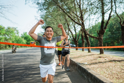 asian runner almost crossing finish line to winning marathon competition