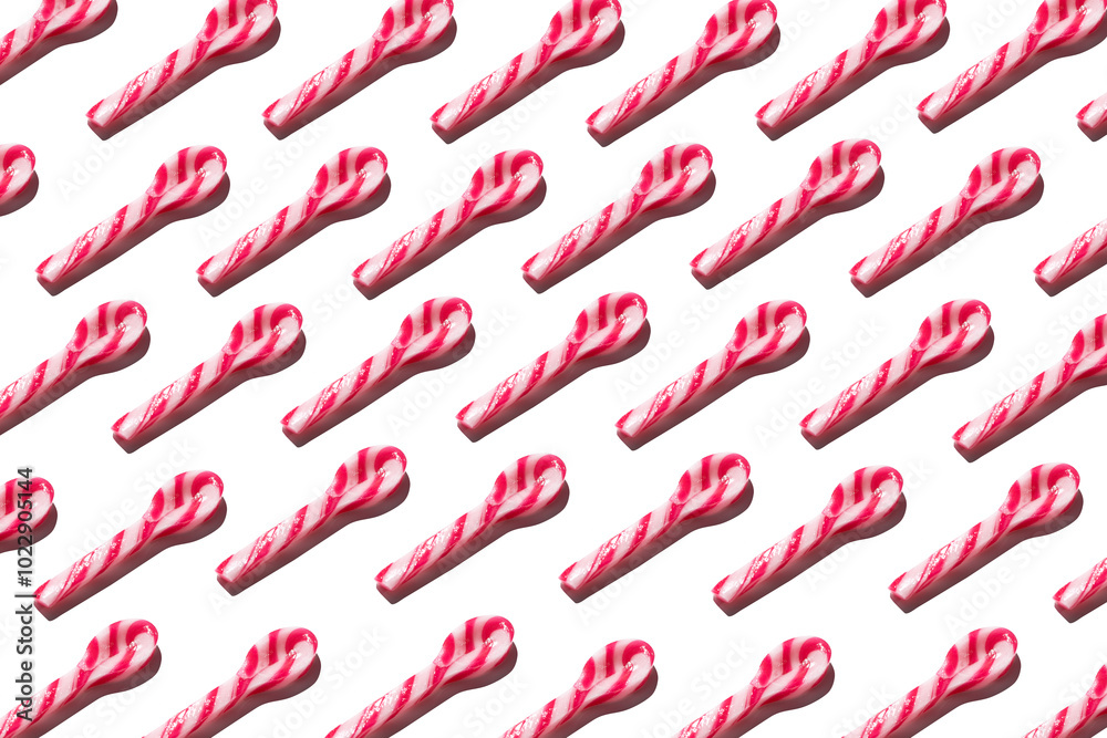 Top view of assorted red and white candy spoon on white background making a pattern