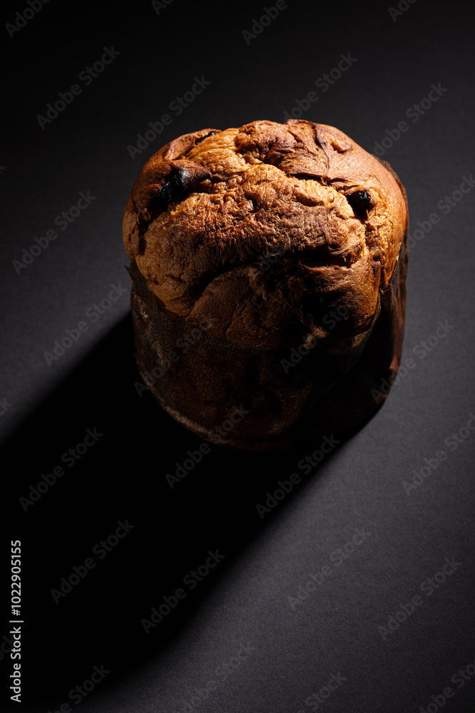 Christmas panettone on a dark background with dramatic lighting copy space in a vertical composition