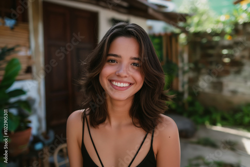 Brunette teenage girl with long brown hair is smiling and wearing a black tank top Free Download Brunette teenage girl with long brown hair is smiling and wearing a black tank top - GFXLoad