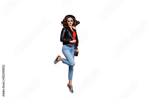 Full length photo of cute charming girl jump send air kiss on her journey attract men wear black leather jacket denim jeans isolated over yellow color background