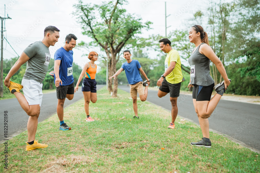marathon runners in sportswear warming up together before competition
