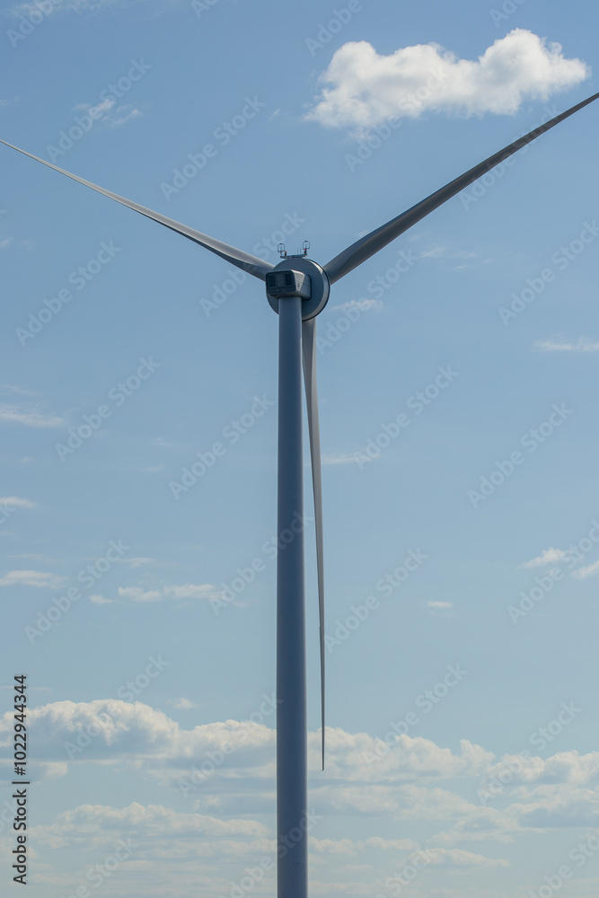Close-up of wind turbine against blue sky. Concept of green, clean, renewable energy. Close-up of wind turbine against blue sky. Concept of green, clean, renewable energy.