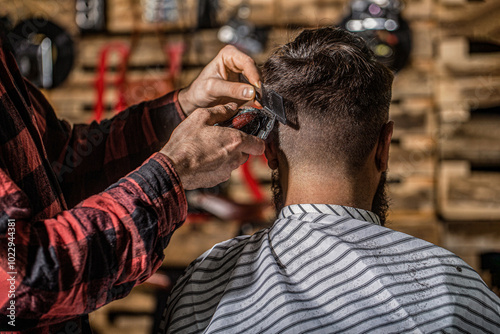 Hands of barber with hair clipper. Haircut concept. Hairstylist serving client at barber shop. Man visiting hairstylist in barbershop