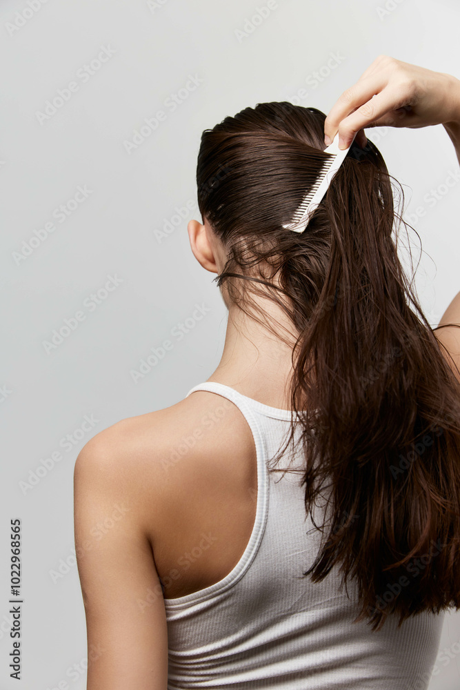 Hair care, combing hair, beauty routine, personal grooming, healthy hair, hair texture, young woman, back view, hair styling, minimalistic background, natural hair color Hair care, combing hair, beauty routine, personal grooming, healthy hair, hair texture, young woman, back view, hair styling, minimalistic background, natural hair color