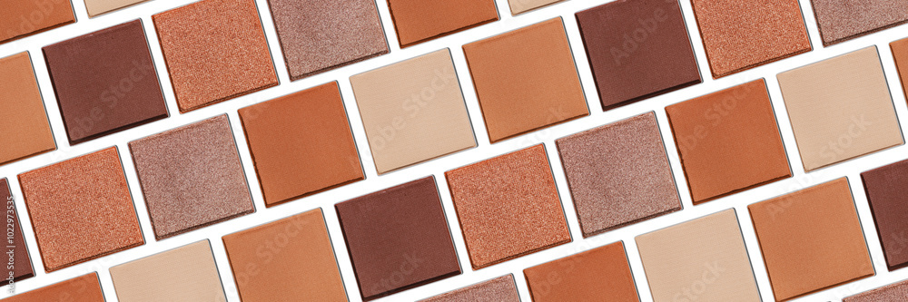 Fototapeta premium Swatches eyeshadow refills as minimal graphic pattern. Matte and glitter pans beige brown copper shade, wide banner, natural light, minimal trend cosmetic background, beauty product, eye makeup