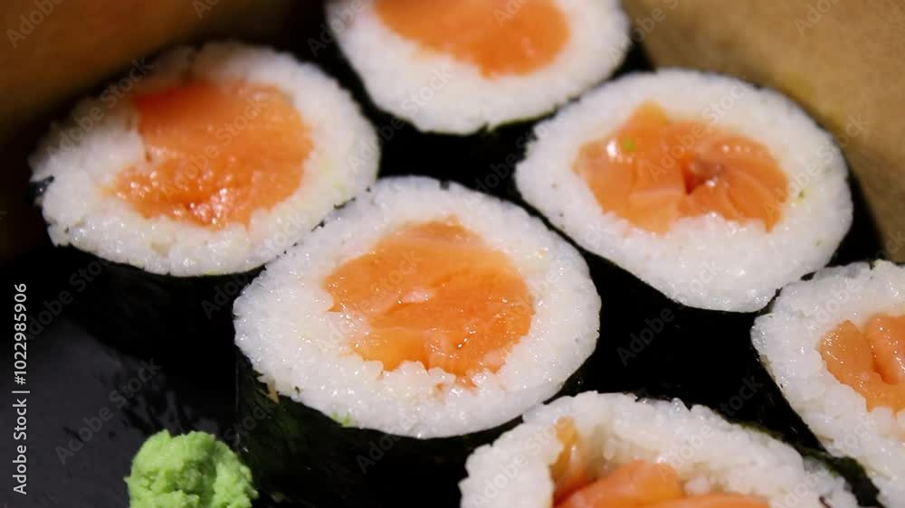 Close up of fresh sushi maki with salmon in a take away box Close up of fresh sushi maki with salmon in a take away box