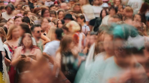 Close-up time-lapse unrecognizable blurry huge crowd of people crossing city street, busy crossroad fast motion, many pedestrians walking crosswalk. Rush hour crowded, people walk, blurred faces photo