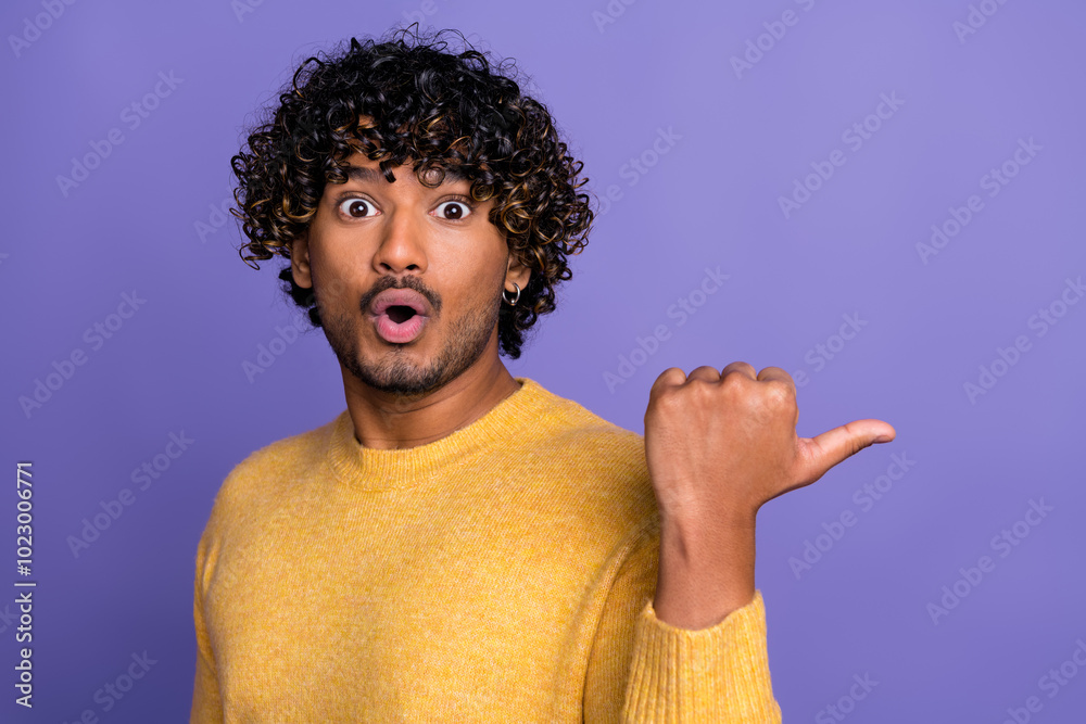 Photo of funny speechless staring man wear trendy yellow clothes recommend empty space isolated on violet color background Photo of funny speechless staring man wear trendy yellow clothes recommend empty space isolated on violet color background