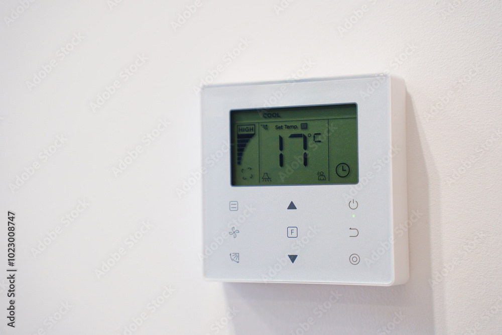 Smart thermostat on the white wall of the room. Smart thermostat on the white wall of the room.