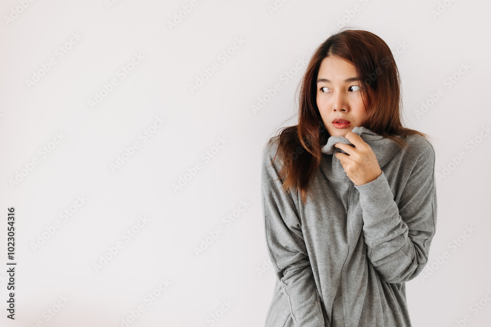Asian Thai woman holding sweater, hiding and covering her face, shy and embarrassing, smelly standing isolated over white background wall. Asian Thai woman holding sweater, hiding and covering her face, shy and embarrassing, smelly standing isolated over white background wall.