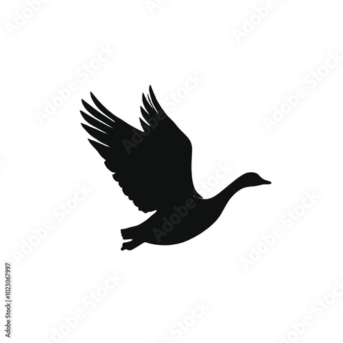 A black silhouette of a flying duck or goose with outstretched wings 