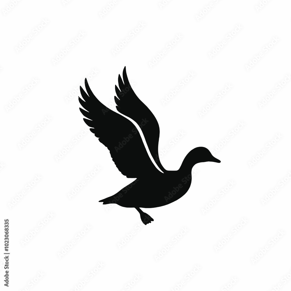 A black silhouette of a flying duck or goose with outstretched wings A black silhouette of a flying duck or goose with outstretched wings