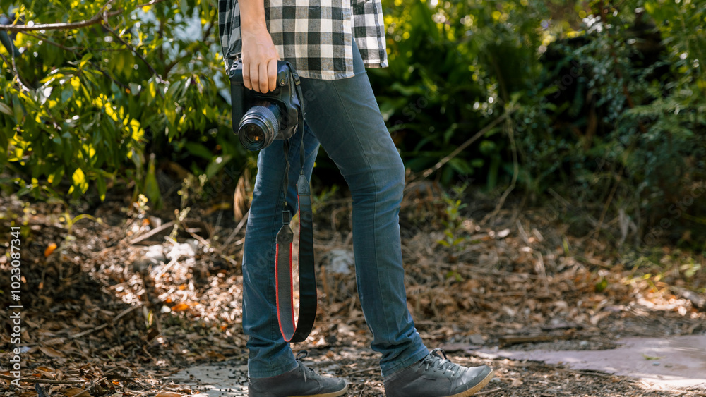 Person walking through nature with dslr camera in hand Person walking through nature with dslr camera in hand