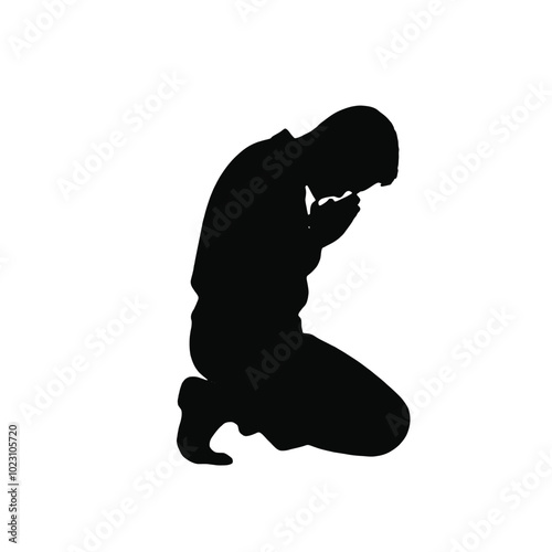 A silhouette of a person kneeling in prayer 