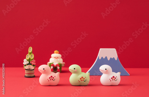 Japanese new year. Zodiac Snake. Snake ornaments and Mt.Fuji and kadomatsu on the red background. 日本のお正月。干支の巳（ヘビ）。赤背景上の巳の置物と富士山と門松。 photo