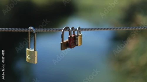 Padlocks Hanging on a Cable on the Background of a Pond. Slow Motions. 4K