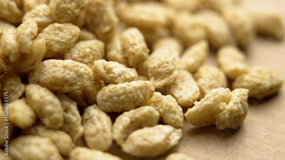Crunchy healthy wholesome morning breakfast cereal flakes on brown paper. Uncooked dry crispy grains. Macro. Rotation Crunchy healthy wholesome morning breakfast cereal flakes on brown paper. Uncooked dry crispy grains. Macro. Rotation