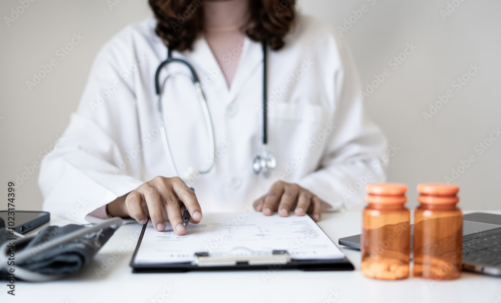 Female doctor holding a medicine bottle is checking the quality of medicine for any side effects the patient or not and recording patient information at the hospital. medical and health care concept Female doctor holding a medicine bottle is checking the quality of medicine for any side effects the patient or not and recording patient information at the hospital. medical and health care concept
