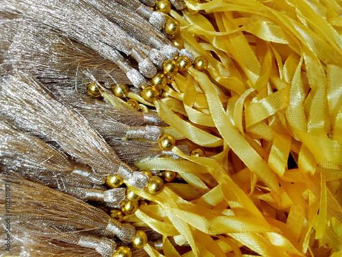 stack of yellow ribbons with yellow tassels of golden color photo