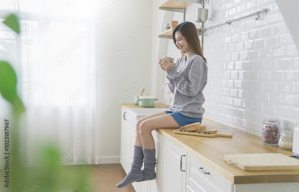 Portrait young beautiful asian woman relax sit on kitchen counter. Smile happy asian girl drink coffee at table home minimal lifestyle. Freelance small business asian owner sme work from home Portrait young beautiful asian woman relax sit on kitchen counter. Smile happy asian girl drink coffee at table home minimal lifestyle. Freelance small business asian owner sme work from home