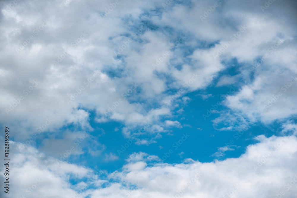 Naklejka premium Vibrant blue sky filled with fluffy white clouds