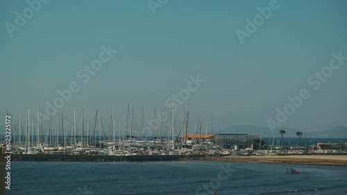 Yacht harbour. A place for ships to moor on the shore in the middle of the sea. Windsurfing in Spain, a surfer goes into the sea to ride a board.