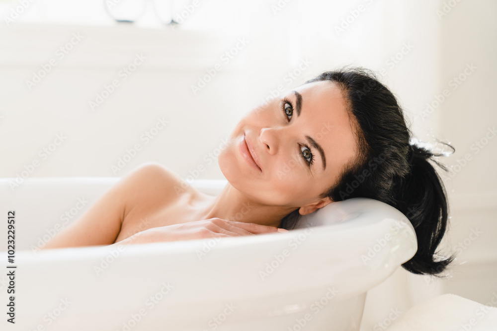 Naked caucasian mature middle-aged woman relaxing while taking shower bath in hot warm water at home looking at camera Naked caucasian mature middle-aged woman relaxing while taking shower bath in hot warm water at home looking at camera