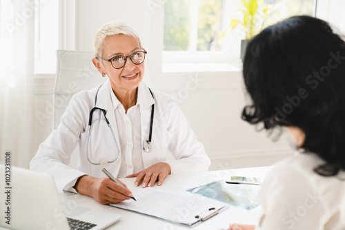 Family doctor general practitioner gynecologist prescribing medicines, health insurance with female patient during hospital appointment