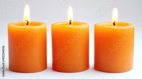 Three pillar candles burning brightly, isolated on a clean white background