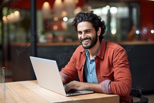 Mexican man working on laptop computer smiling smile.