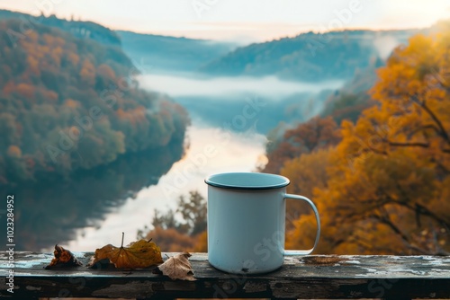 A serene morning by the river with a white mug resting on a wooden railing surrounded by colorful autumn foliage